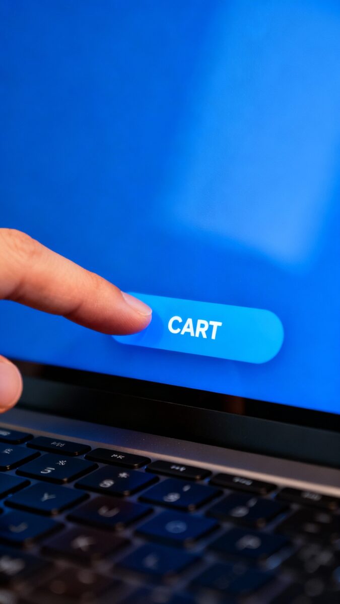 Closeup of sticky bar CTA button on laptop screen, glossy blue, finger hovering